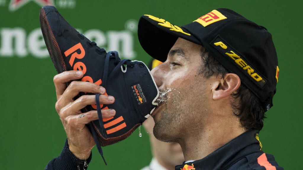 Daniel Ricciardo drinking champagne from a boot. Image source: thescore.com. Photo.
