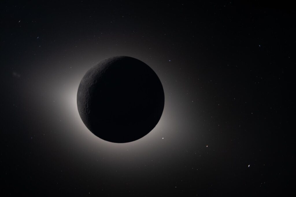 The Moon completely blocks the Sun, providing a nearly 54-minute total eclipse and revealing far more than can be seen from Earth. The corona forms a glowing halo around the dark lunar disk, exposing details of the Sun's outer atmosphere that are normally hidden by its brightness.