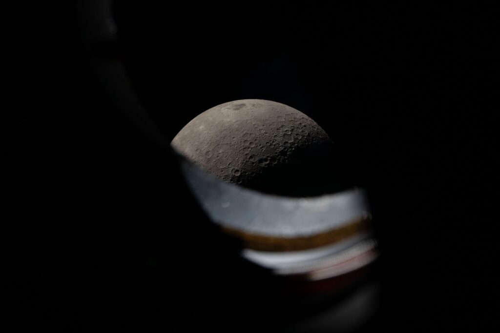 The Moon peeks out from behind the windowsill of the Orion spacecraft during the lunar flyby. The Artemis II crew spent about 7 hours at Orion's windows, taking photographs and recording observations of the Moon to share with scientists on Earth.