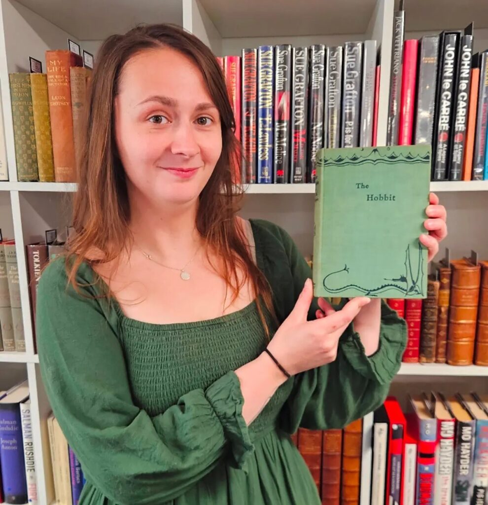 Rare book specialist Caitlin Reilly poses with a first edition of 'The Hobbit.' Image source: nytimes.com. Photo.