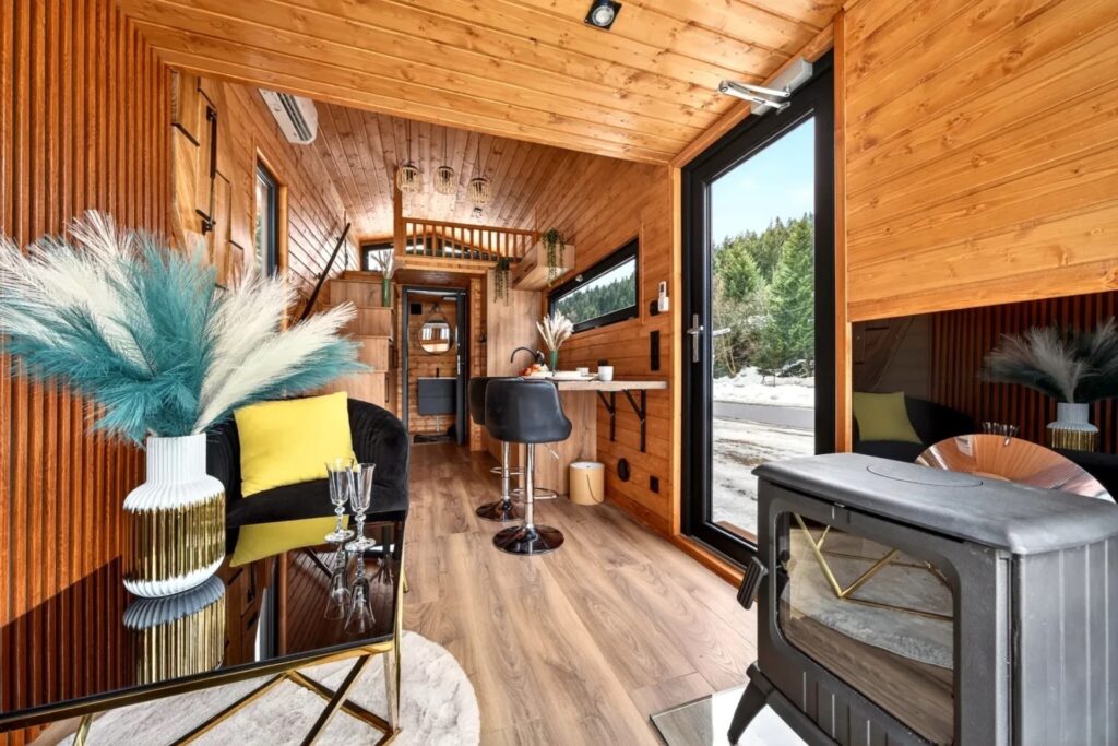 Living room interior: wood-burning stove, sliding doors, and Scandinavian spruce cladding. Image source: craft-house.eu. Photo.