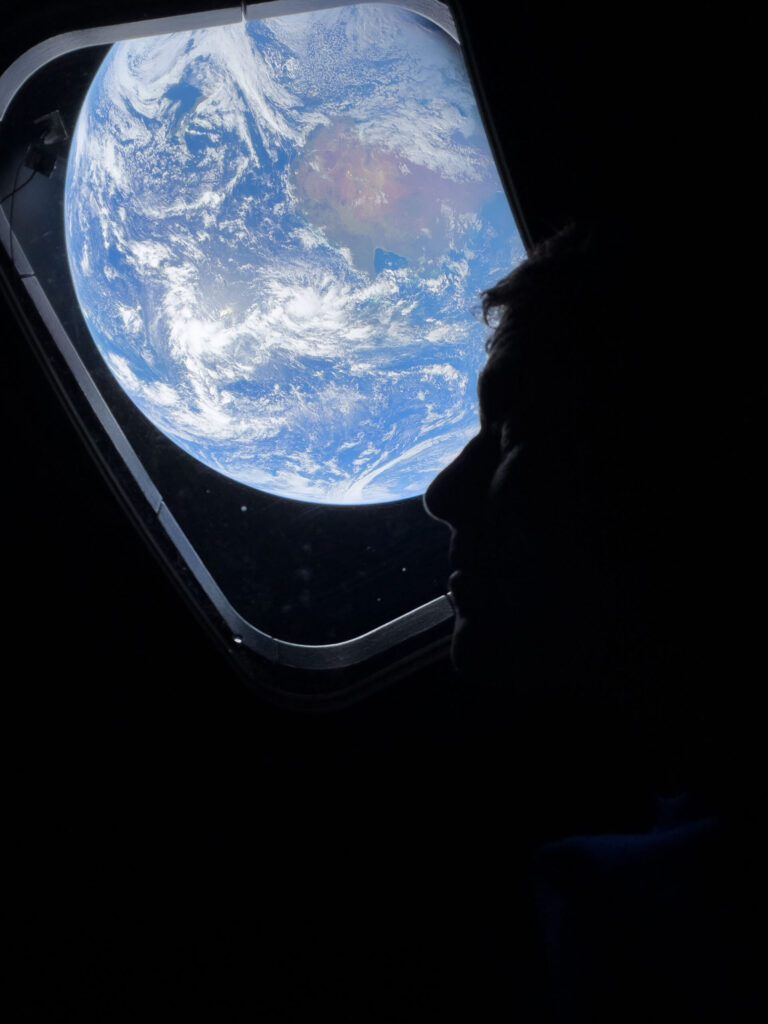 Astronauts take photos with Earth visible through the porthole