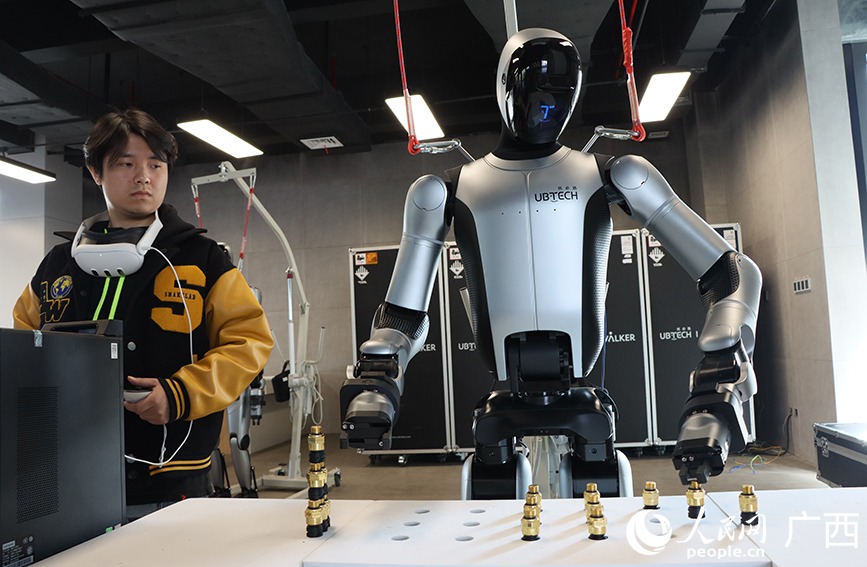 A robot trains under an instructor's guidance at the Dongfeng Liuzhou Motor factory. Image source: en.people.cn