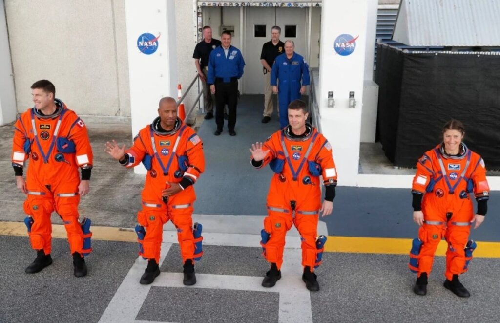 The Artemis 2 crew in orange spacesuits heads to the launch pad. Image source: NASA. Photo.