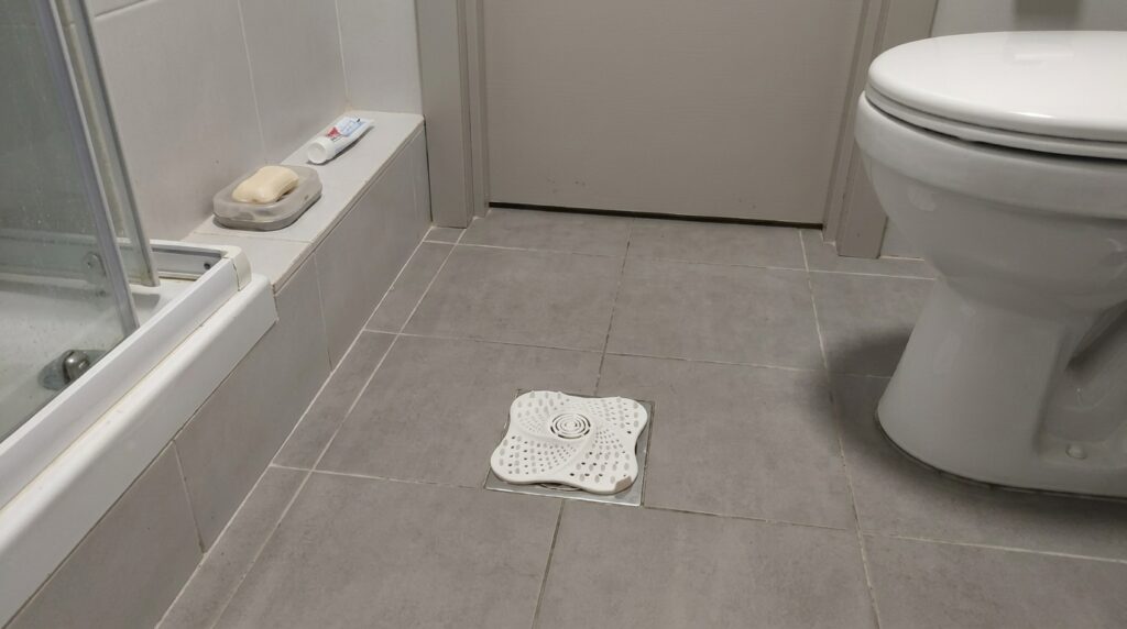 Silicone drain cover for the shower. Been in the shower since January — not a single clog, not a single plumber call. Photo.