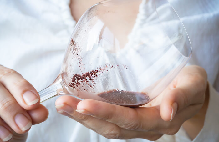 Sediment collected in the remains of wine from a bottle. Photo.