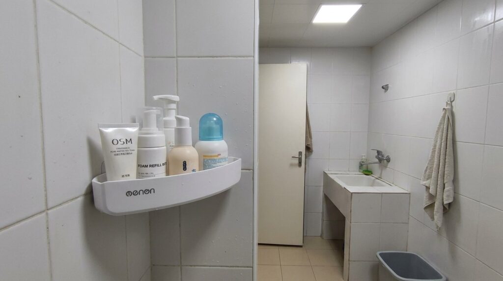 Corner bathroom shelf — no drilling required. Just a shelf, but it's so useful. Photo.