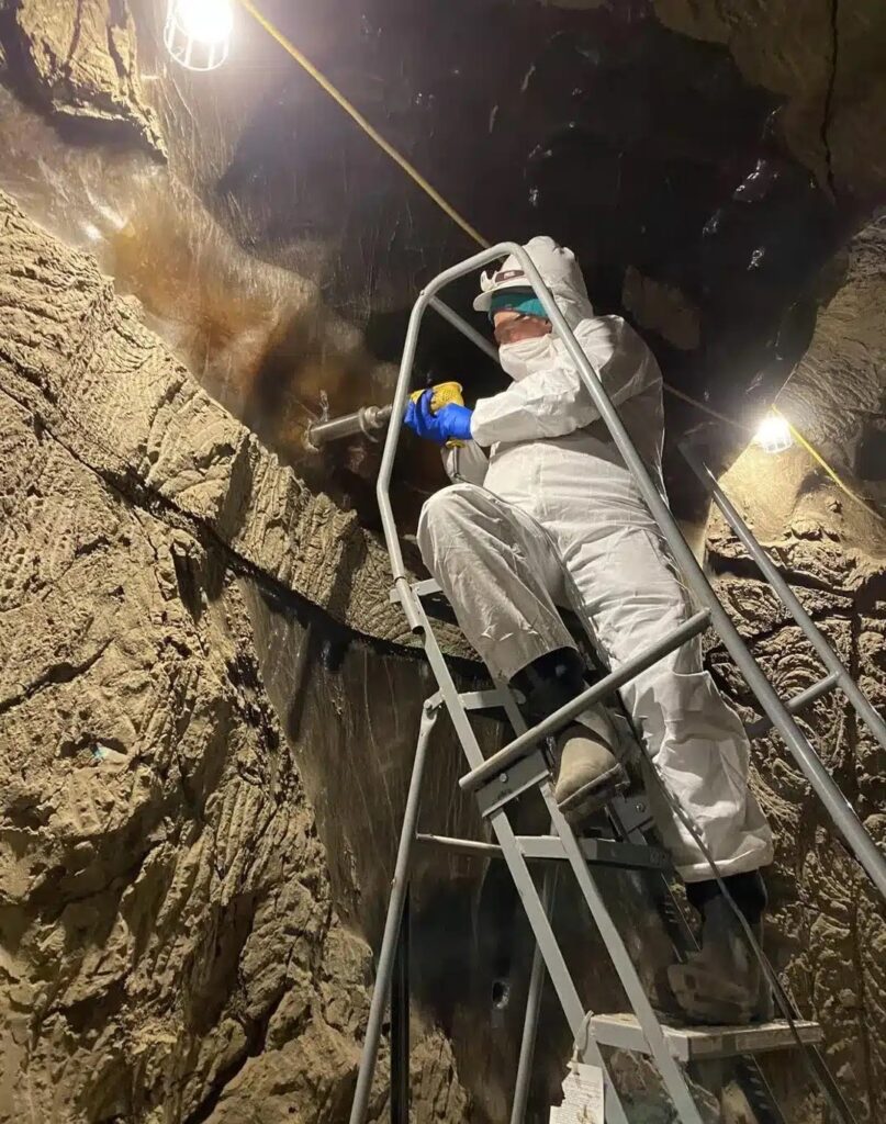 A scientist drills ancient permafrost in the research tunnel in Alaska. Photo.