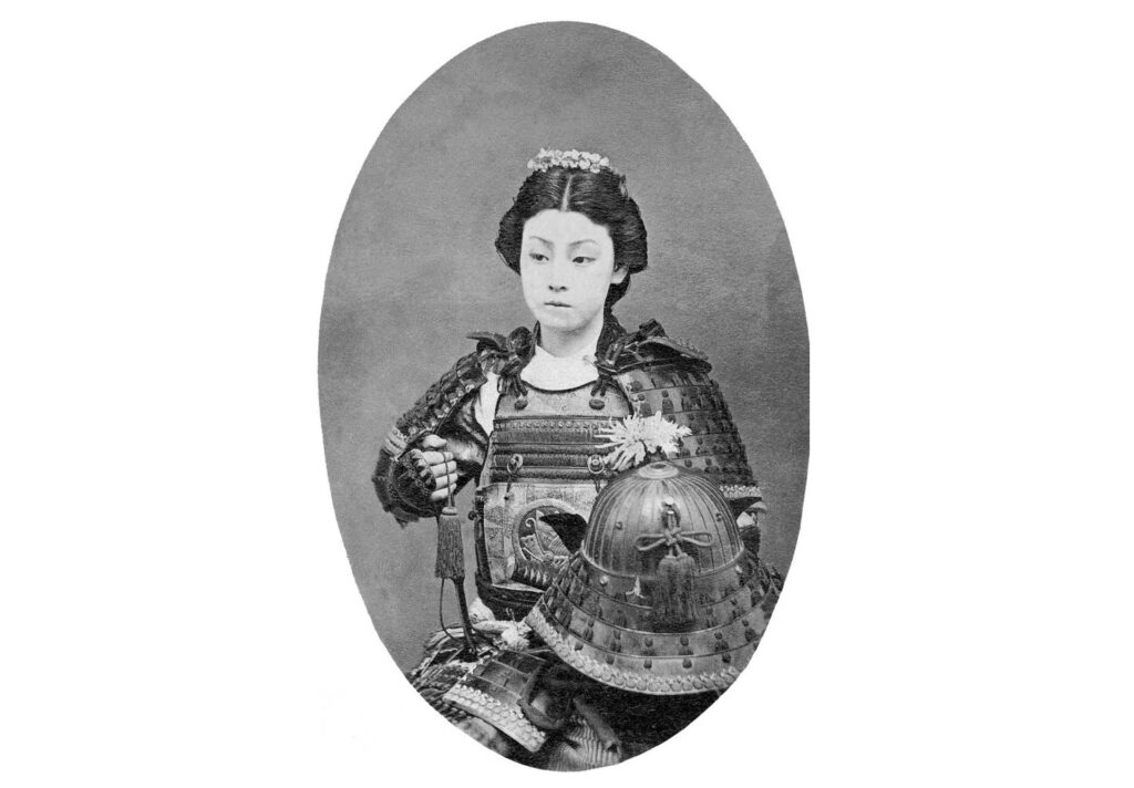 An 1870 photograph showing an actress in armor posed as a female samurai. Photo.