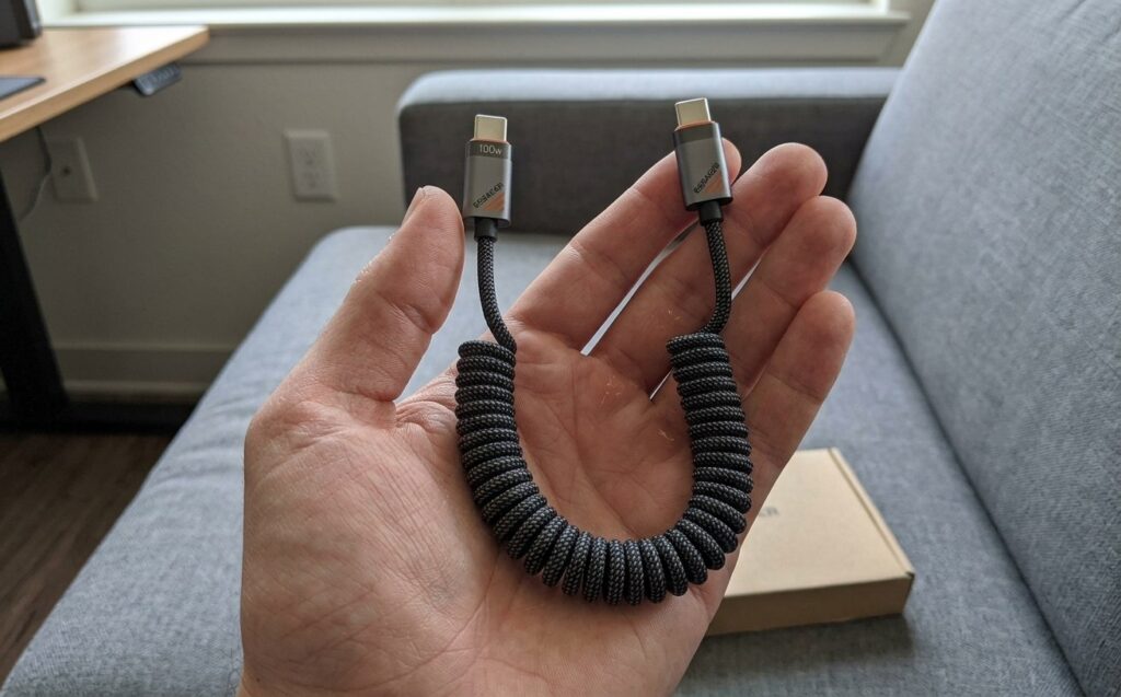 A convenient cable for charging your phone in the car. The cable is neatly coiled and doesn't dangle all over the car. Photo.