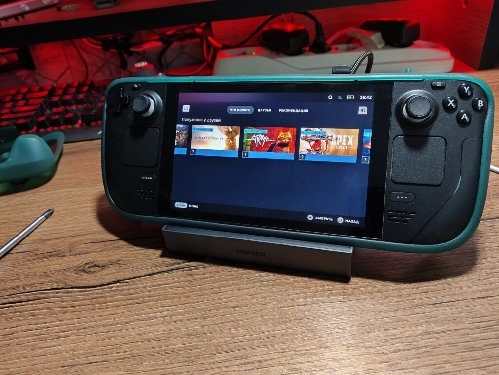 Place the console in the dock, it charges there, and the picture is displayed on a big screen. Photo.
