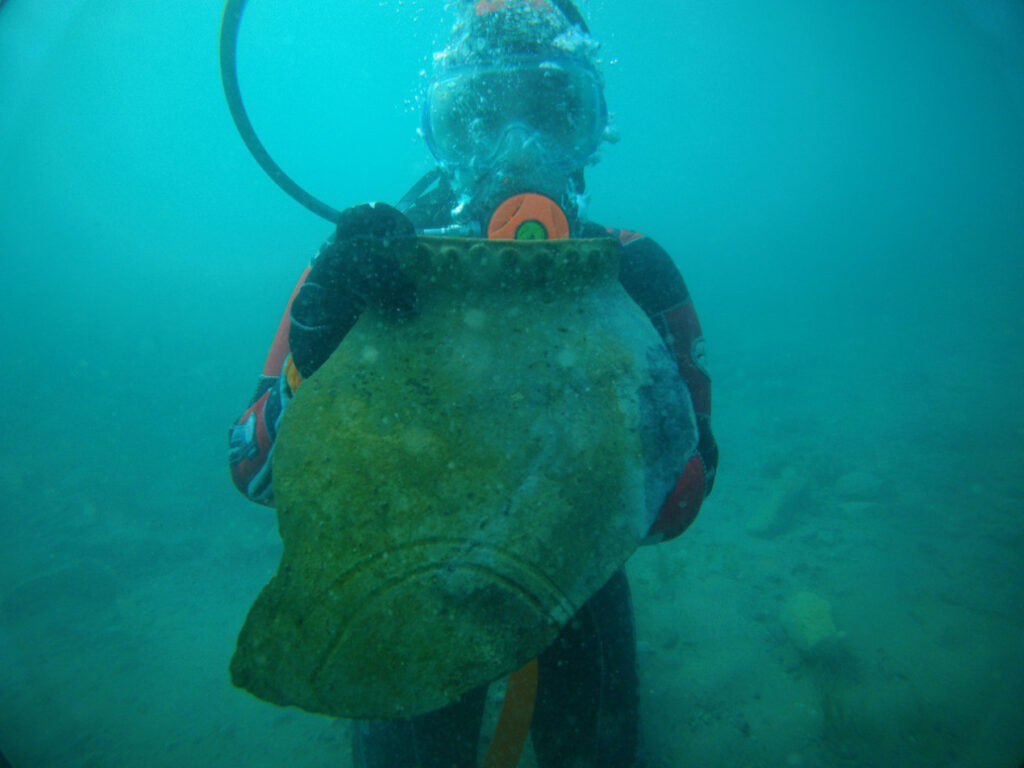 A diver with part of an ancient jug from the submerged ruins discovered at the bottom of Lake Issyk-Kul. Image source: rgo.ru. Photo.