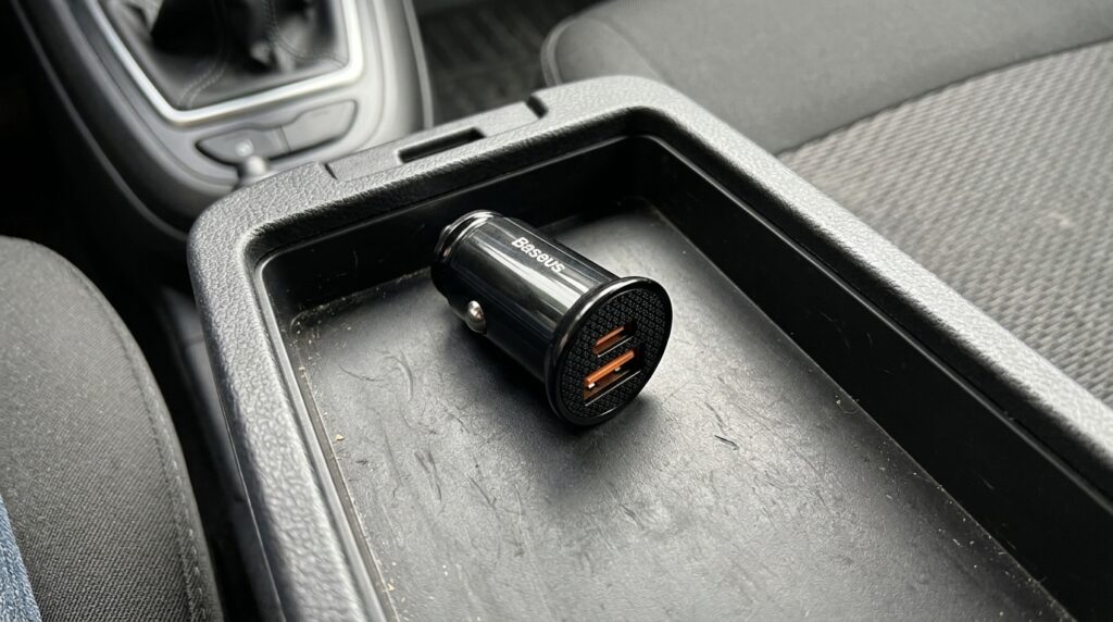 Baseus car charger to replace the stock stub. Sticks out of the cigarette lighter, doesn't annoy — and fast-charges the iPhone. Photo.