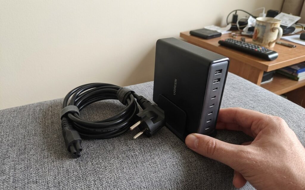 The box includes the charger itself, the cable, and a vertical stand