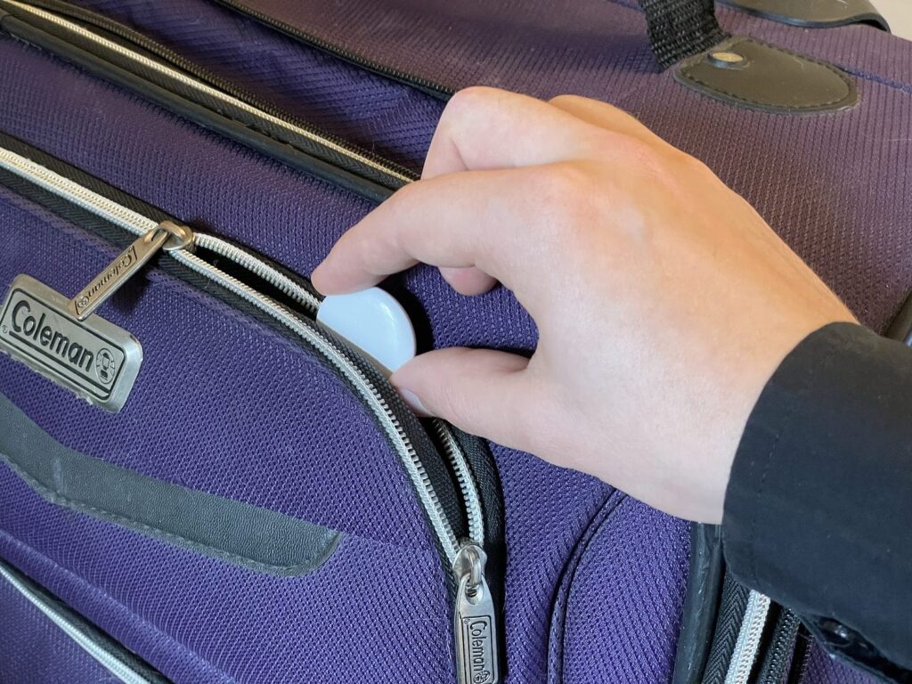 How to place an AirTag in a suitcase. Don't bury the tracker too deep — it may get a weaker signal.