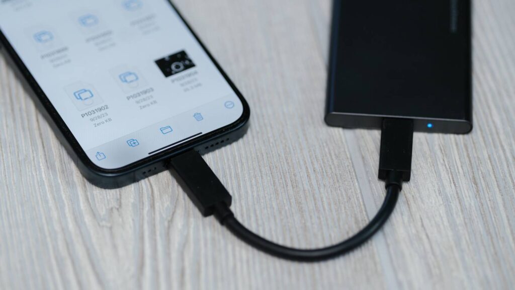Why an external SSD is riskier than a basic flash drive. An external SSD connected during a file transfer. Photo.
