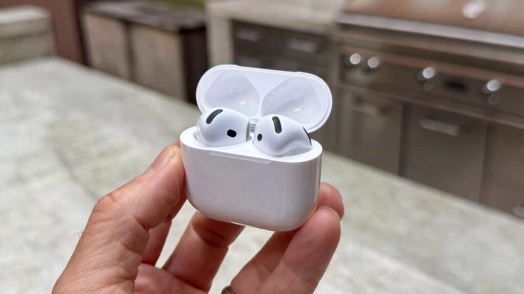 AirPods 5 earbuds in hand