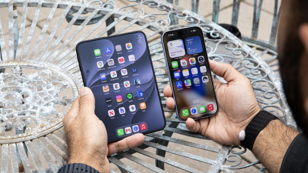 A person holding an unfolded iPhone Duo and a regular iPhone